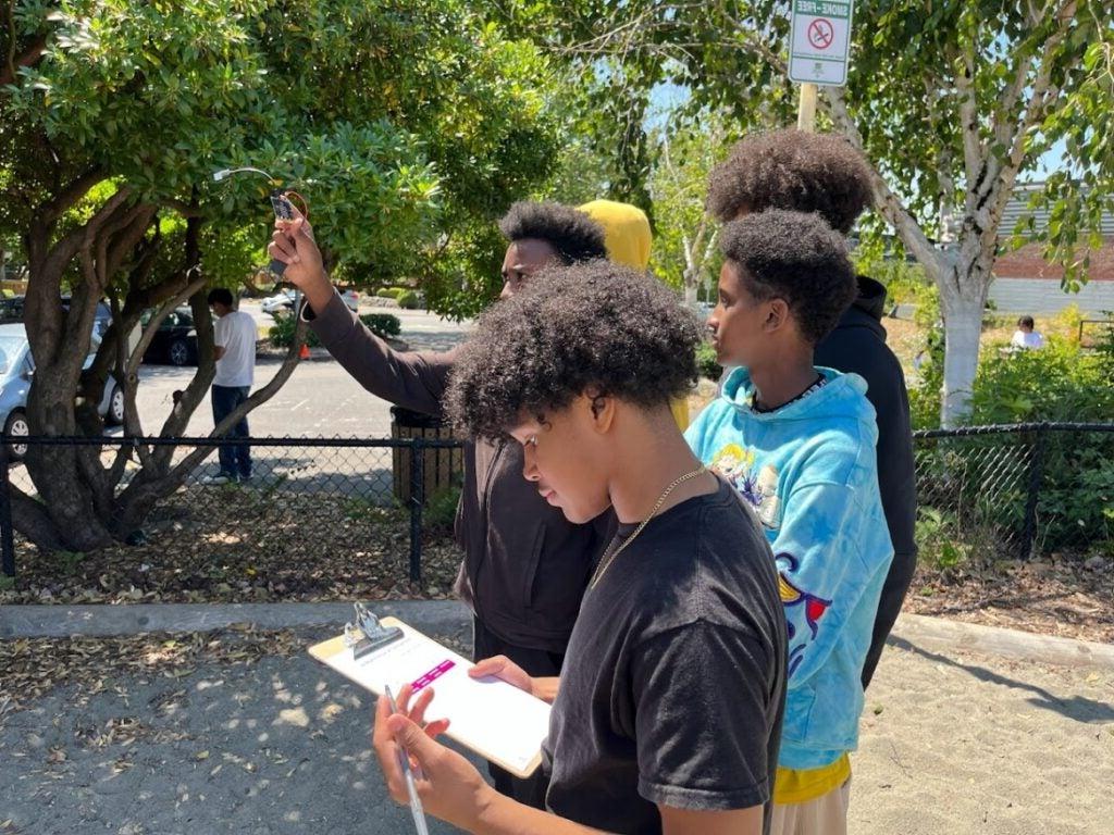 Students conducting experiment using micro bit outside of school